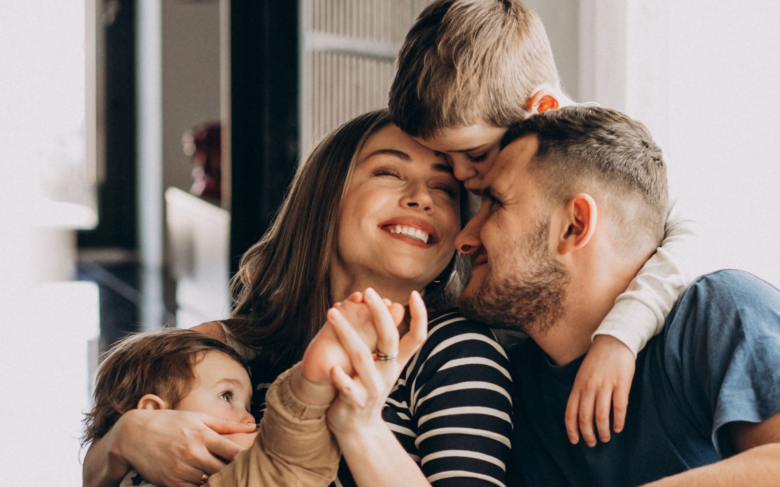 Una familia en su casa, abrazada